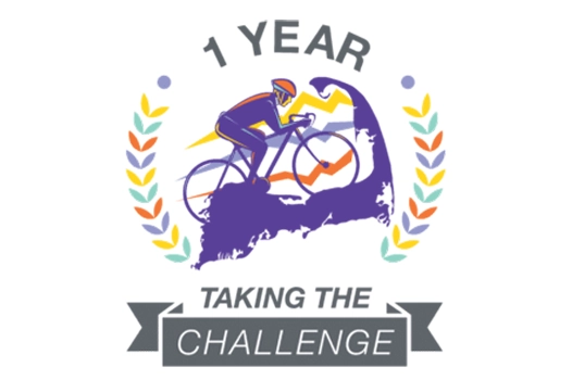 Badge with cyclist and laurel wreath reading '1 Year Taking the Challenge.